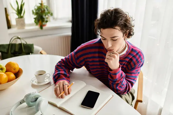 A young non-binary individual studies thoughtfully in their warm, modern apartment. — Stock Photo