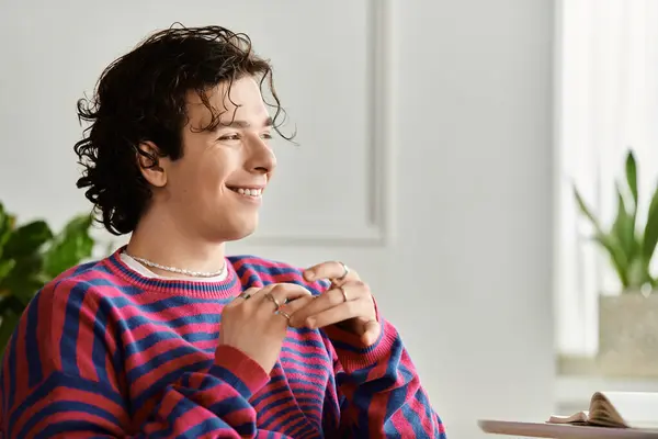 Curly-haired non-binary person enjoys a moment in their vibrant, stylish apartment setting. — Stock Photo