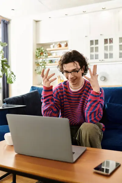 A young non binary person with curly hair engages in an animated conversation at home. — Stock Photo