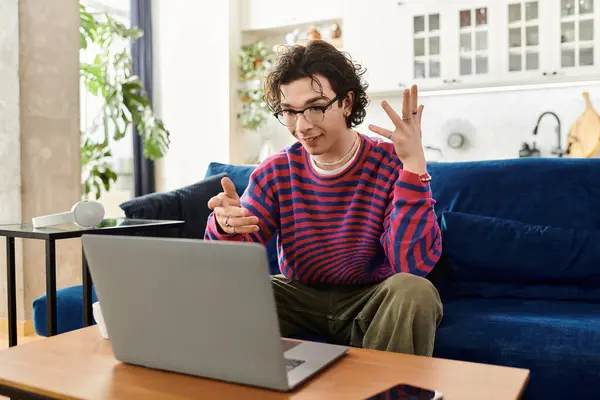 A young non-binary person chats happily in a colorful striped sweatshirt. — Stock Photo