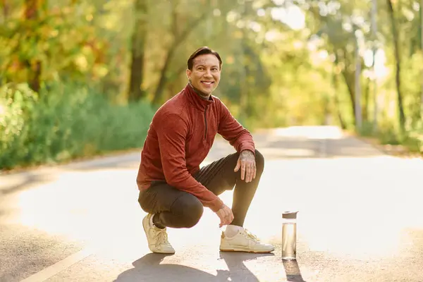 Handsome man dressed in trendy athletic attire enjoys his time outdoors, surrounded by nature. — Stock Photo
