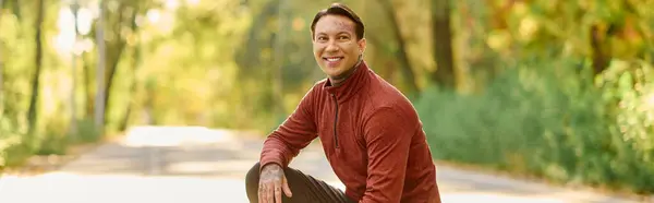Young man with tattoos poses confidently in a trendy outfit surrounded by vibrant fall colors — Stock Photo