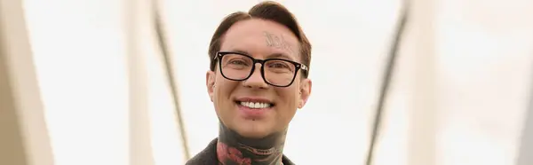 Hombre tatuado muestra su traje de moda por la arquitectura moderna. - foto de stock