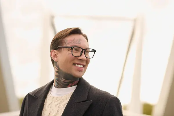 Hombre tatuado disfruta del aire libre en traje de moda con una sonrisa segura. - foto de stock