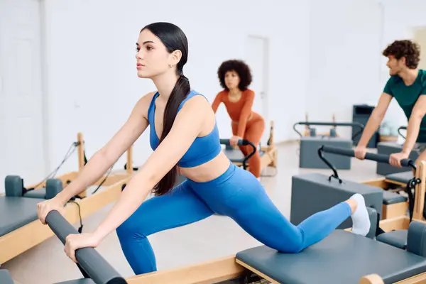 I partecipanti si impegnano in un impegnativo allenamento pilates, migliorando la forza e la flessibilità. — Foto stock