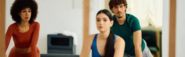 Participants focus on their movements during an energetic pilates class in a studio space. — Stock Photo