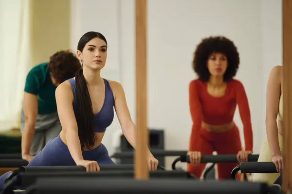 Participants focus on their movements during a vibrant pilates session in the studio. — Stock Photo
