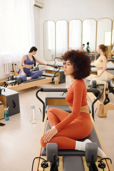 Participants enhance strength and flexibility through pilates routines in a modern studio. — Stock Photo
