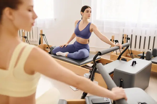 Two individuals engage in a pilates session, boosting core strength and flexibility. — Stock Photo