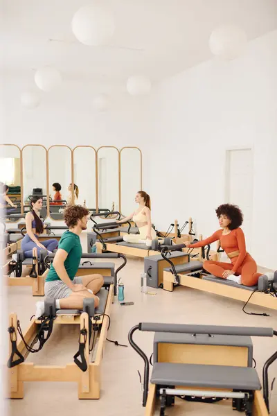 Pilates participants of all skill levels practice together in a calm, bright studio. — Stock Photo