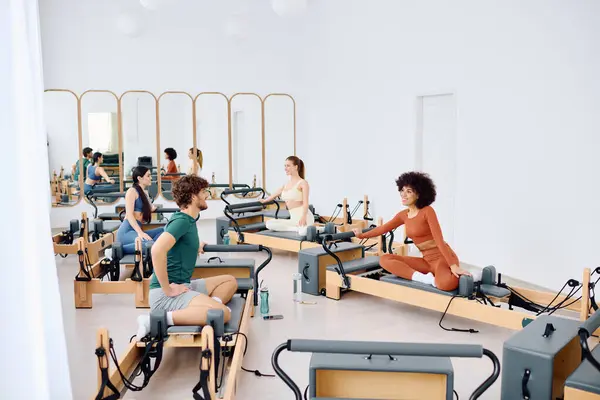 Des personnes concentrées pratiquent le pilates dans un studio lumineux pour augmenter la force et la flexibilité. — Photo de stock