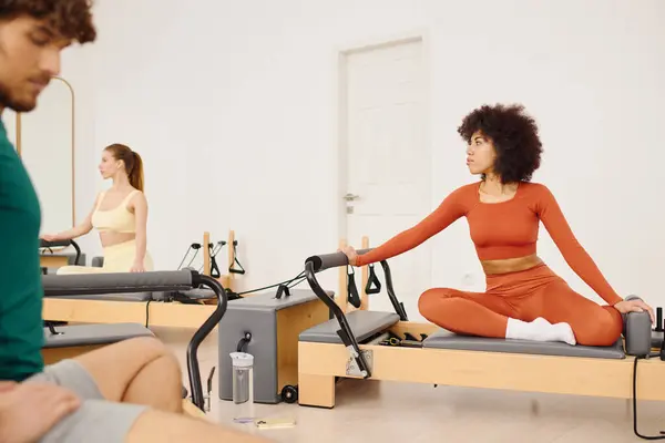 Os participantes fazem pilates para aumentar a força e flexibilidade em um ambiente calmante. — Fotografia de Stock