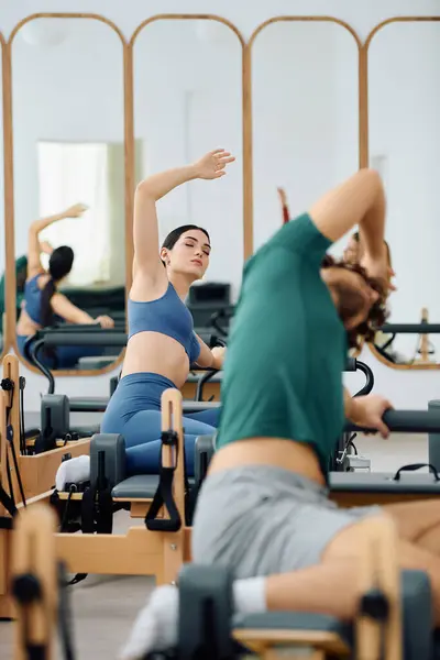 Two individuals engage in a challenging pilates session to boost strength and flexibility. — Stock Photo
