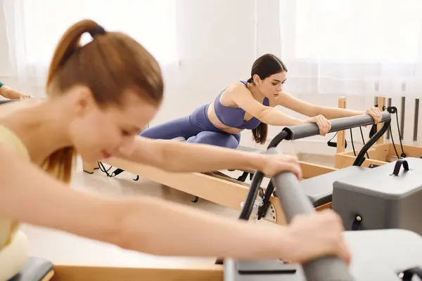 Duas pessoas fazem pilates em um estúdio brilhante, melhorando sua força e flexibilidade. — Fotografia de Stock
