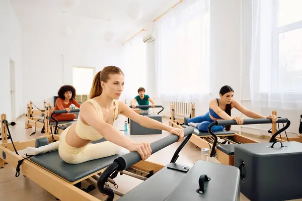Participants focus intently on their pilates practice in a modern, airy studio setting. — Stock Photo