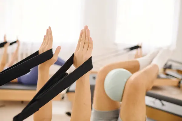 Pilates participants improve flexibility and core strength with resistance bands. — Stock Photo