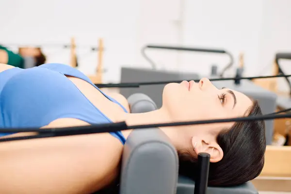 Praticar movimentos focados em equipamentos especializados em um ambiente de estúdio de pilates vibrante — Fotografia de Stock