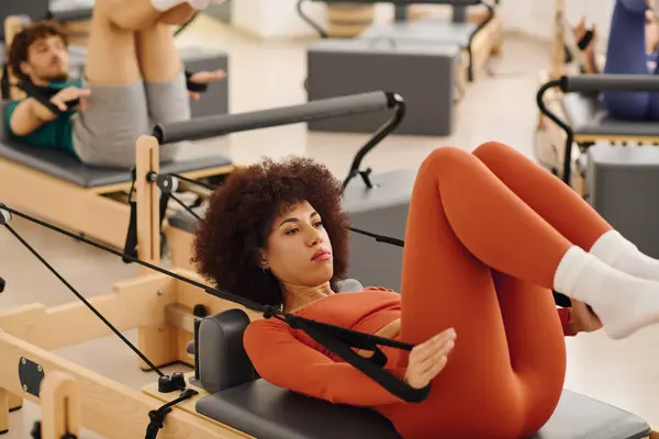 Participants concentrate on their routines during a lively pilates class in a spacious studio. — Stock Photo