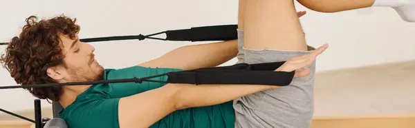 An athlete uses a reformer for an intense pilates workout, boosting strength and flexibility. — Stock Photo
