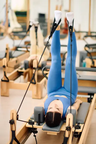 I partecipanti praticano pilates sui riformatori, aumentando la forza e la flessibilità in uno studio calmo. — Foto stock