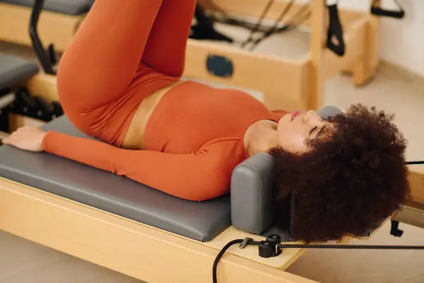 A dedicated person practices pilates in a studio, focusing on core strength and flexibility. — Stock Photo