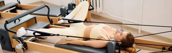 A dedicated athlete performs dynamic pilates, displaying strength and flexibility in a calm studio. — Stock Photo