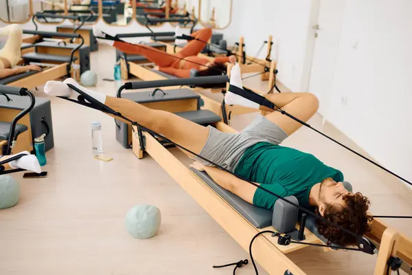 Participants focus on strengthening their core and flexibility during a lively pilates session — Stock Photo