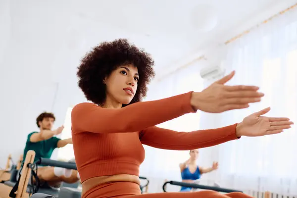 Os participantes fazem pilates em um estúdio brilhante, aumentando a força e flexibilidade do núcleo juntos. — Fotografia de Stock