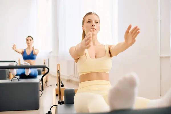 Participants focus on pilates to boost core strength and flexibility in a bright studio. — Stock Photo