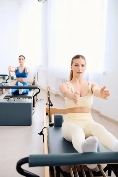 Two individuals practice pilates in a bright studio, boosting their strength and flexibility. — Stock Photo