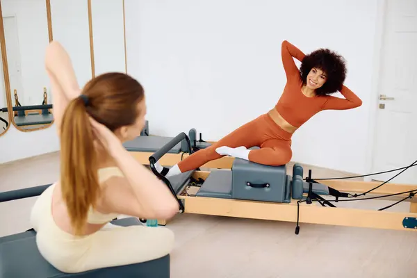 Dos individuos participan en un entrenamiento de pilates, demostrando forma y colaboración en el estudio. - foto de stock