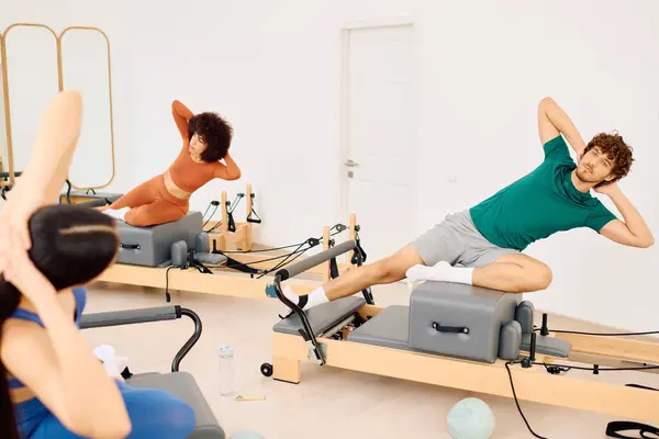 In a bright pilates studio, individuals work out on reformers to boost strength and flexibility. — Stock Photo