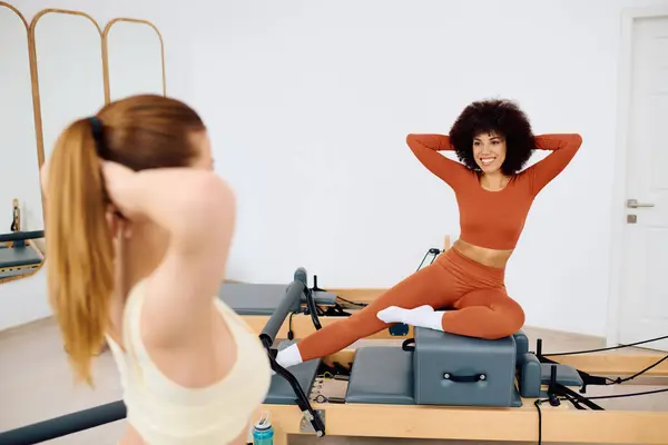 Two vibrant people enjoy a lively pilates workout, showcasing joy and fitness in a studio. — Stock Photo