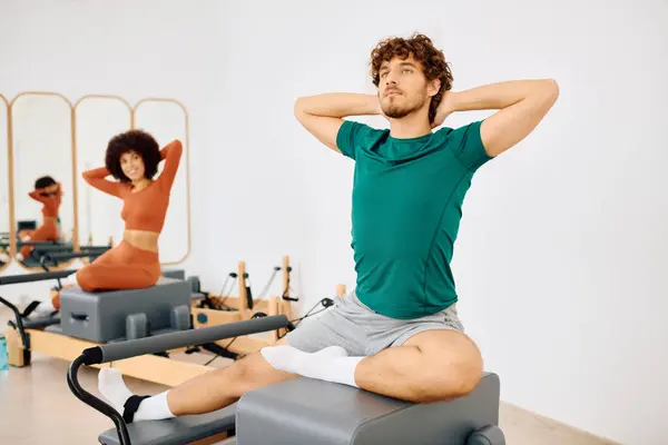 Duas pessoas praticam pilates dinâmicos, mostrando força e foco em um ambiente chique. — Fotografia de Stock