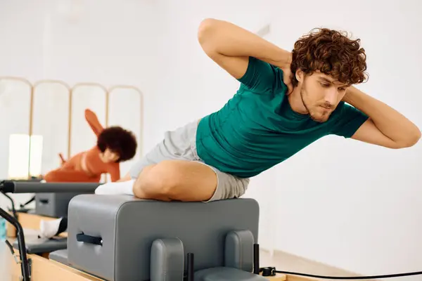 Two people practice pilates, demonstrating strength and flexibility in a calm studio. — Stock Photo