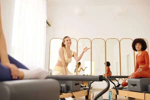 Participants engage in a lively pilates class, sharing smiles and motivation with each other. — Stock Photo