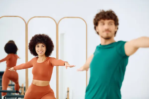 Two fitness enthusiasts engage in a pilates workout, showcasing their determination and strength. — Stock Photo