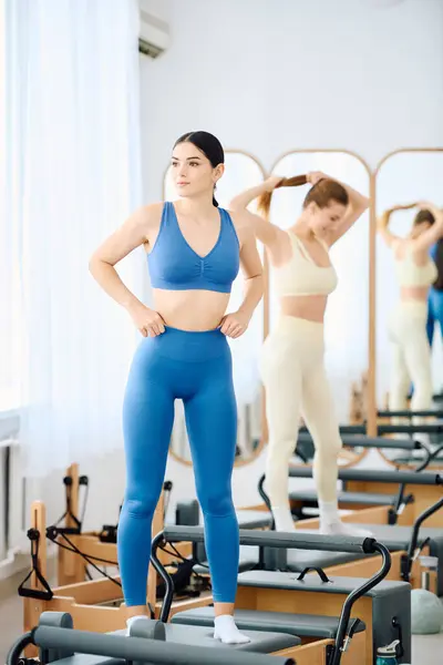 Two individuals participate in a focused pilates workout, enhancing their strength and flexibility. — Stock Photo