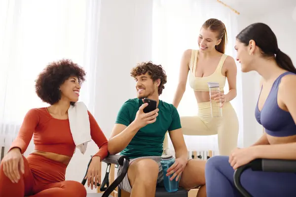 Groups of friends enjoy a lively discussion while relaxing in a bright and inviting pilates studio. — Stock Photo