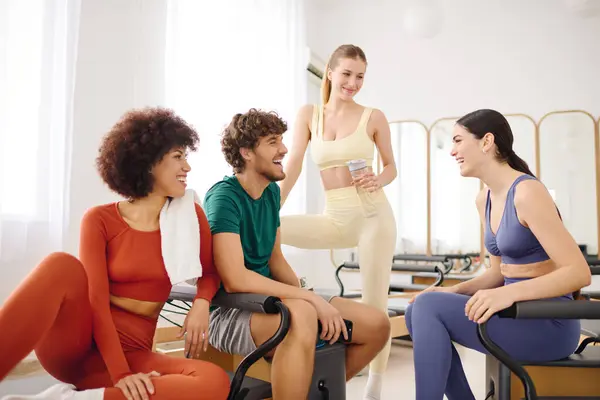 Gli amici condividono risate e relax in un luminoso studio di pilates dopo la loro sessione di allenamento. — Foto stock