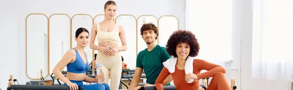 Cuatro personas dedicadas participan en una sesión de pilates, mostrando sus técnicas y trabajo en equipo. - foto de stock