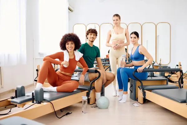 Four friends engage in a dynamic pilates class, showcasing playful poses and camaraderie. — Stock Photo
