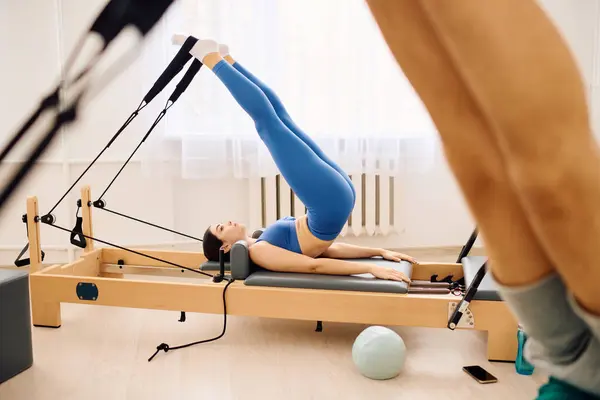 Una persona pratica un avanzato Pilates muoversi su un riformatore in uno studio calmo. — Foto stock