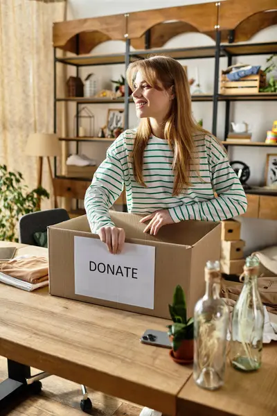 Young woman joyfully organizes and donates clothes in a cozy, eco-friendly space. — Stock Photo