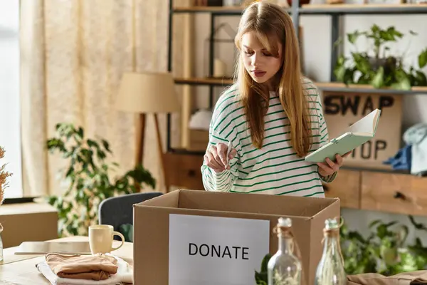 A young woman organizes her clothes, preparing to donate them in her cozy living space. — Stock Photo