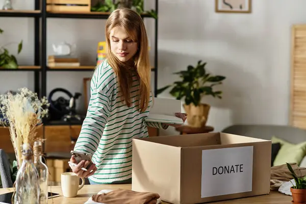 Young woman organizes her wardrobe, preparing to donate clothes for sustainability efforts. — Stock Photo