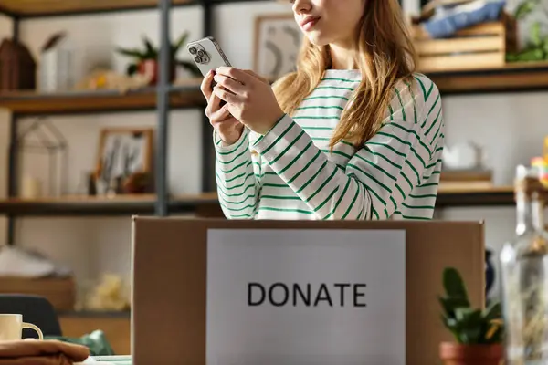 A young woman carefully organizes her clothes to donate, promoting sustainability and kindness. — Stock Photo