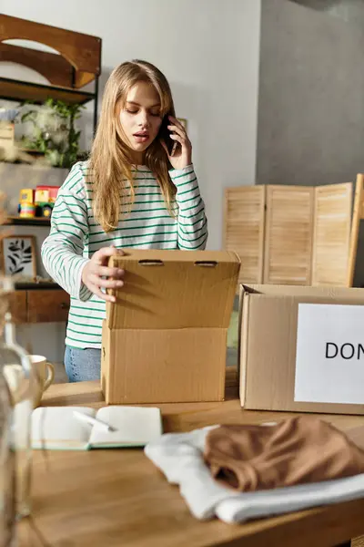 A pretty young woman sorts her clothes while speaking on the phone, promoting sustainability. — Stock Photo