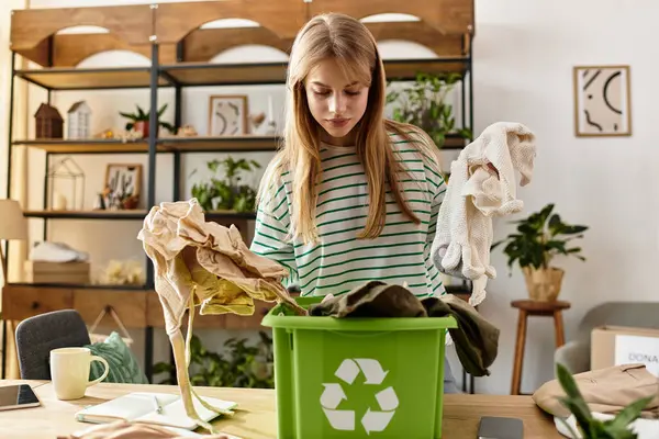 A young woman sorts and recycles her clothes, promoting an eco-friendly lifestyle at home. — Stock Photo