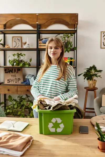 Uma jovem classifica suas roupas para reciclagem, abraçando hábitos ecológicos. — Fotografia de Stock